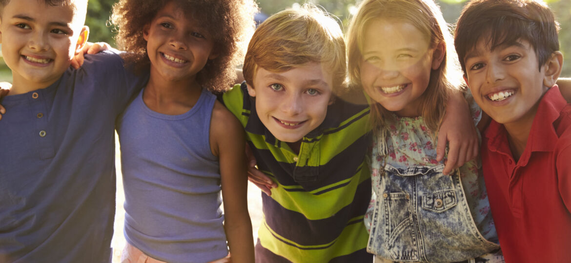 Portrait Of Five Children Having Fun Outdoors Together